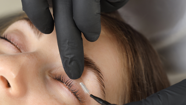 A beauty therapist carefully working on eyelashes